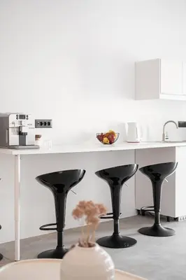 a kitchen with a white table and black stools at ALS - casa casa group in Chania Town
