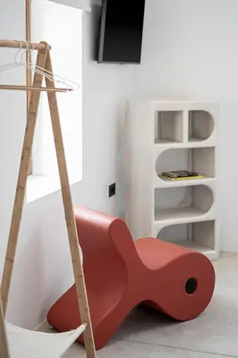 a red chair sitting in a room with a ladder at ALS - casa casa group in Chania Town