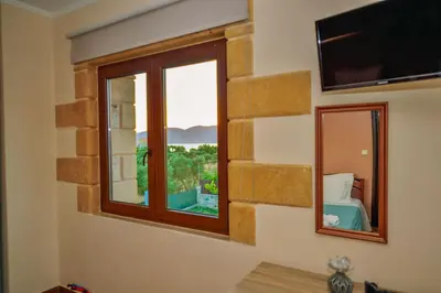 a room with a window with a bed and a mirror at Villa Archontissa in Análipsis