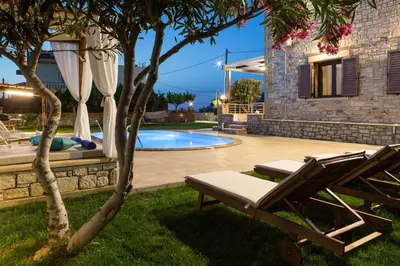 a yard with a pool and a chair next to a house at Villa Archontissa in Análipsis