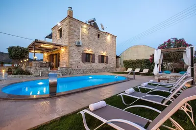 a backyard with a pool and chairs and a house at Villa Archontissa in Análipsis