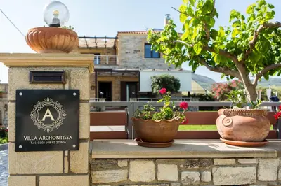 a sign with two potted plants on a bench at Villa Archontissa in Análipsis