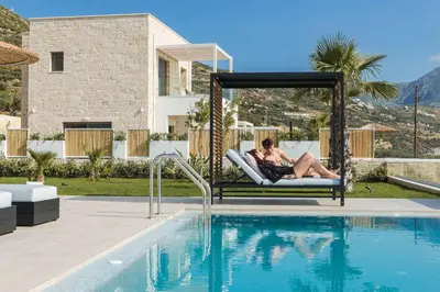 a couple laying on a swing next to a swimming pool at Actea Seaview Villas I 