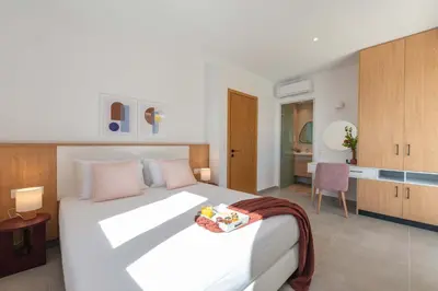 a bedroom with a large white bed with pink pillows at Actea Seaview Villas I 