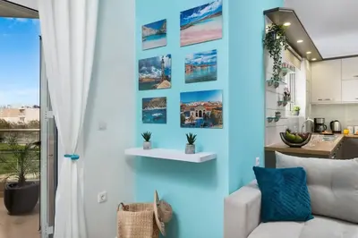a living room with a blue wall with pictures on it at New cozy apartment near the center of Chania in Chania Town