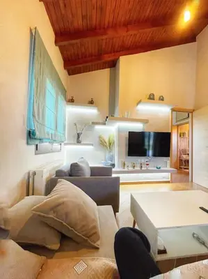 a living room with a couch and a tv at Kathiana cozy apartment in Kathiana