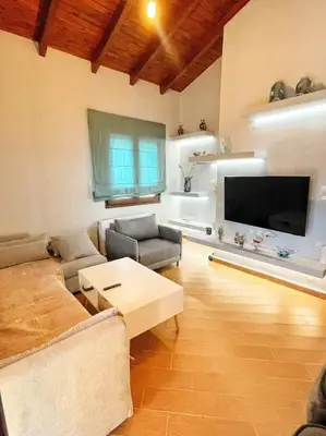 a living room with a couch and a flat screen tv at Kathiana cozy apartment in Kathiana
