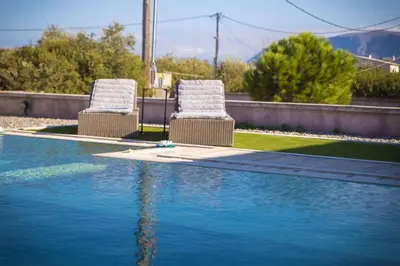 two chairs sitting next to a swimming pool at The Alcove Studio Chania in Chania Town