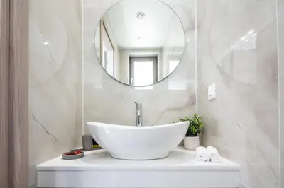 a bathroom with a white sink and a mirror at Oinolithos Luxury Villas in Kalamaki Chanion