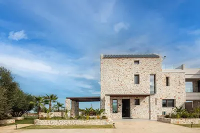 a stone house with a black roof at Oinolithos Luxury Villas in Kalamaki Chanion