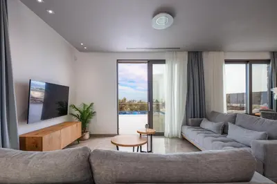 a living room with a couch and a tv at Oinolithos Luxury Villas in Kalamaki Chanion