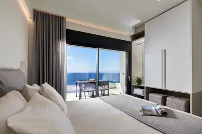 a bedroom with a bed and a large window with a view at Pachnes Luxury Apartments - Heated Pool, Sea View in Kounoupidhianá