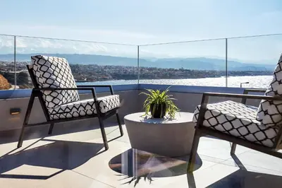 two chairs and a table on a balcony with a view at Pachnes Luxury Apartments - Heated Pool, Sea View in Kounoupidhianá