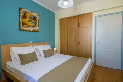 a bedroom with a large bed with a blue wall at Be Crete - vista Lazareta in Chania Town
