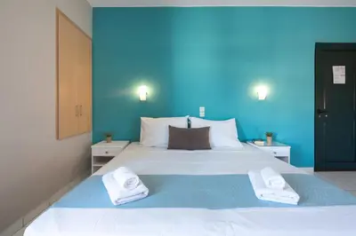 a blue bedroom with a large bed with towels on it at Hermes Hotel in Kissamos