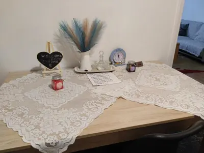 a table with a white lace table cloth on it at EMMY APARTMENT in Chania Town