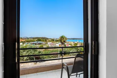 a chair sitting on a balcony with a view of the ocean at Sun Beach Apartment in Chania 15 in Chania Town