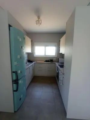 a kitchen with white cabinets and a blue refrigerator at Nostalgico cottage in Chania Town