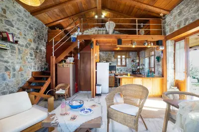 a living room with a table and chairs and a kitchen at Fortino Villa in Chorafakia
