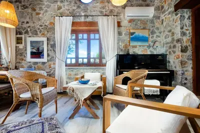 a living room with a stone wall at Fortino Villa in Chorafakia