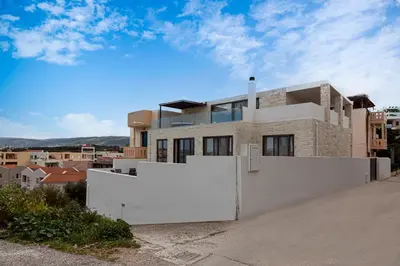 a house with a white fence in front of a city at Perla Dream Luxury Villa in Chania Town
