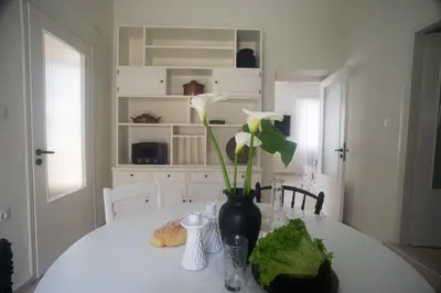 a white table with a vase with flowers on it at Tatiana's Garden House in Chania Town