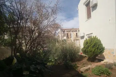 a garden in front of a white building at Tatiana's Garden House in Chania Town