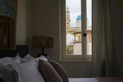 a bedroom with a bed and a window with a clock tower at Tatiana's Garden House in Chania Town
