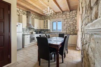 a kitchen with a dining room table and chairs at Villa Rea Chania in Argoulidhés