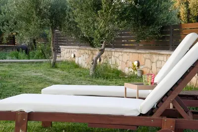 a couple of lounge chairs in a yard at Villa Rea Chania in Argoulidhés