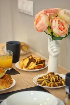 a table with plates of food and a vase with flowers at Mirma Halepa superior studio in Chania Town