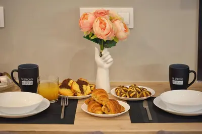 a table with plates of food and a bouquet of flowers at Mirma Halepa superior studio in Chania Town
