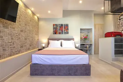 a bedroom with a bed and a brick wall at Mirma Halepa superior studio in Chania Town