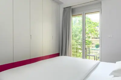 a bedroom with a large bed and a window at Artful City Loft with Rooftop Terrace, Near Beach in Chania Town