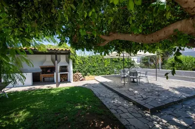 a table and chairs under a tree in a yard at Eleni Residence by the sea in Ropanianá