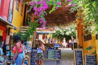 a group of people walking down a street with flowers at Apartment - Sleeps 4 & Free Parking in Chania Town