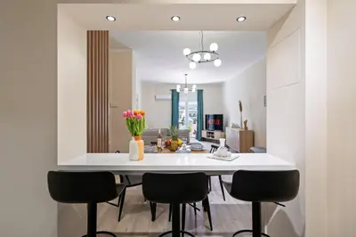 a kitchen with a large white island with black chairs at Georginas home in city center in Chania Town