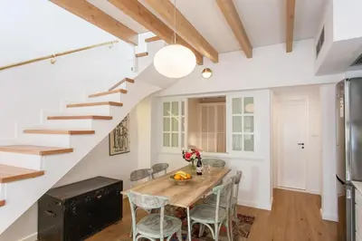 a dining room with a table and chairs and a staircase at House of Sirri in Chania Town