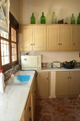 a kitchen with green glass vases on the cabinets at Traditional Villa with pool in Sfakia in Ímbros