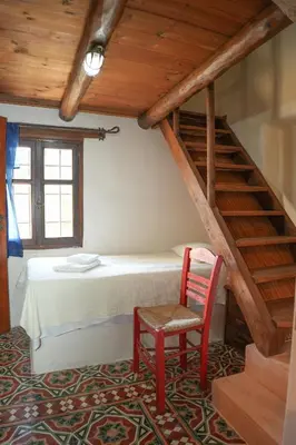 a bedroom with a bed and a red chair at Traditional Villa with pool in Sfakia in Ímbros