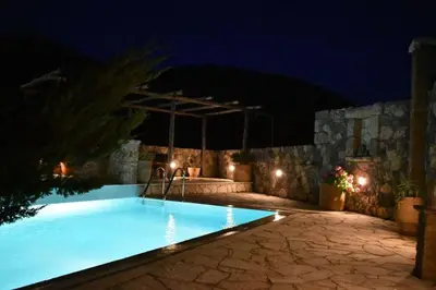 a swimming pool at night with lights at Traditional Villa with pool in Sfakia in Ímbros