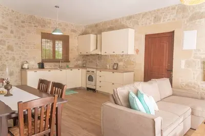 a kitchen and a living room with a couch and a table at Fanouria's home in Kalleryianá
