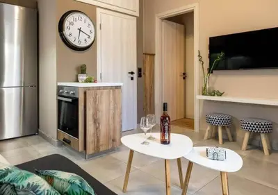 a living room with two tables and a clock on the wall at Eva Cozy Apartment in Chania Town