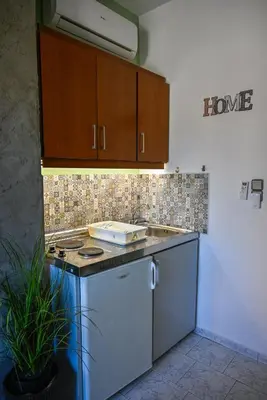 a kitchen with a sink and a stove and cabinets at Kydonia apartments in Plataniás