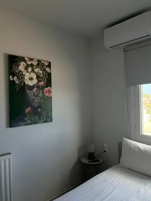 a bedroom with a painting of a woman with flowers on the wall at A & G Apartments in Kolymvari