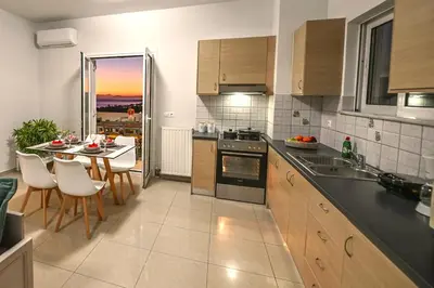a kitchen with a table and a dining room at A & G Apartments in Kolymvari