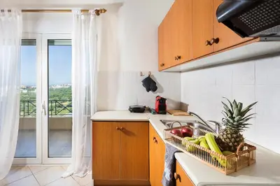 a kitchen with a sink and a dish rack with fruit at Kds Overlooking Chania in Chania Town