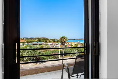 a view of the ocean from a balcony with a chair at Sun Beach Apartments in Chania 09 11 in Chania Town