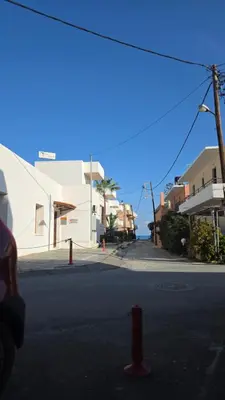 a red fire hydrant in the middle of a street at Kristina Stelios Apartment in Plataniás