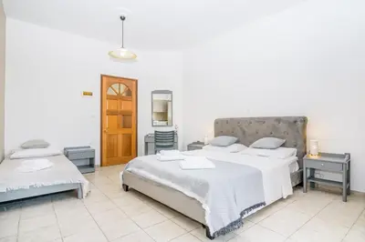 a bedroom with two beds and two tables at Kristina Stelios Apartment in Plataniás